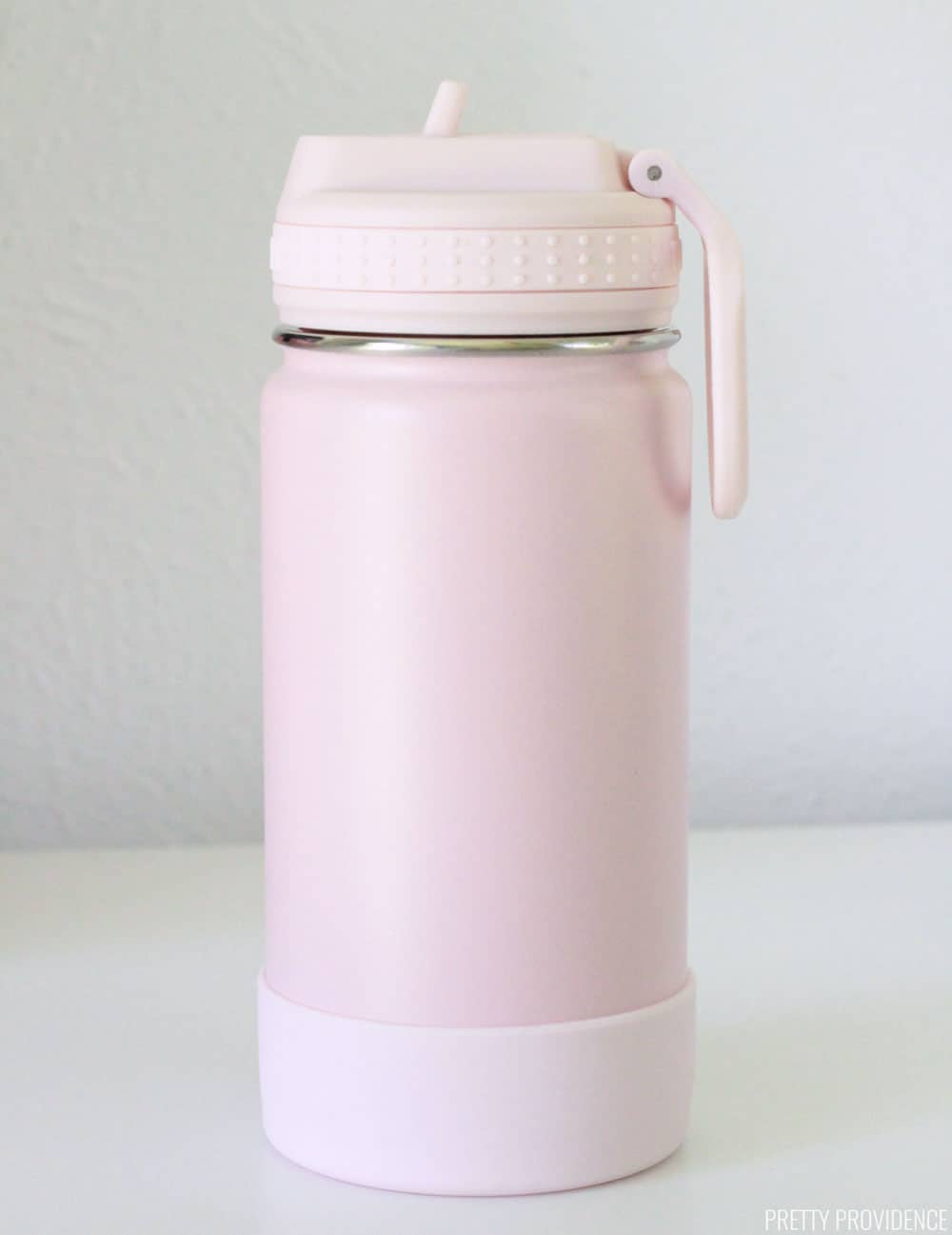 Pink water bottle on a white table.