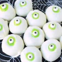Halloween Cake Balls that look like Eyeballs. Green cake dipped in white candy, green icing and candy eyeballs.