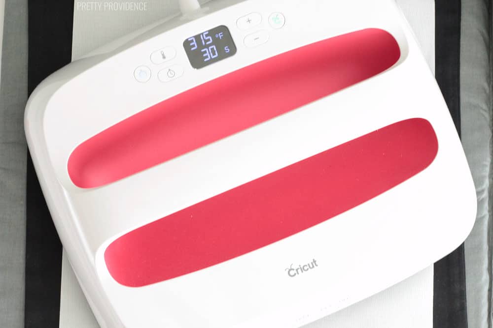 Cricut EasyPress 2, white with red (raspberry) accent, 10x12 size. EasyPress is over an iron-on protective sheet.