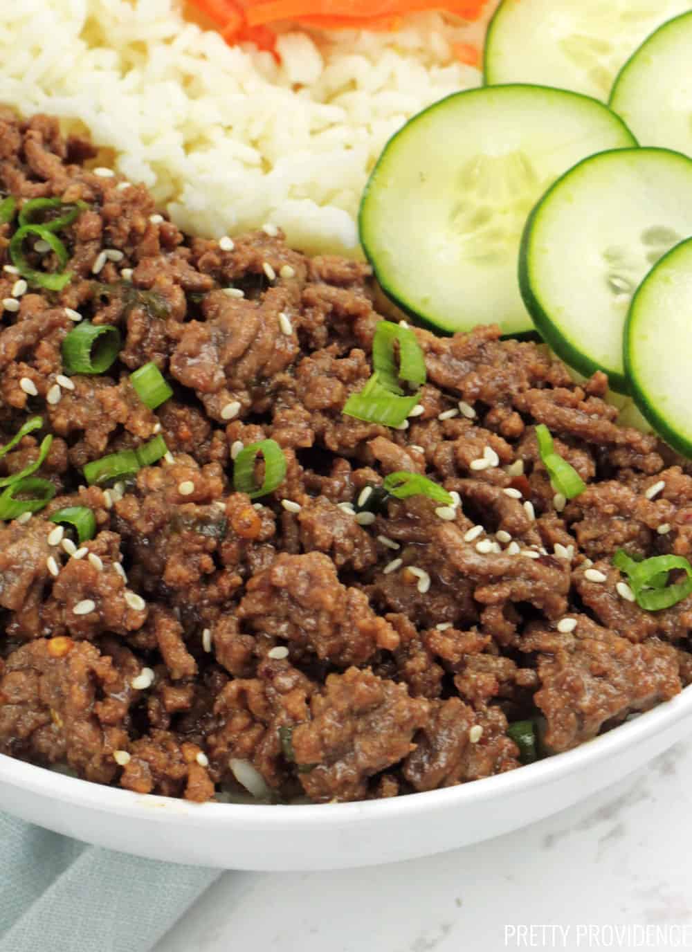 Korean Ground Beef and Rice bowl close-up with sliced cucumbers on top.