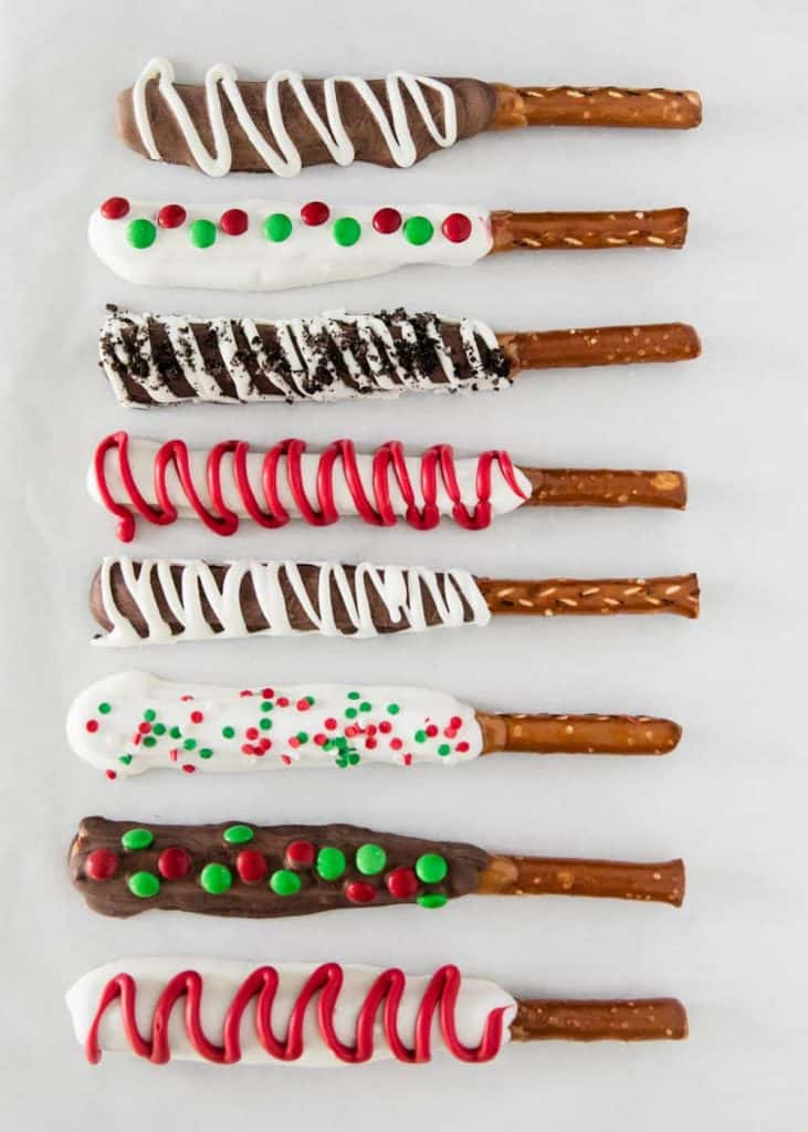 Chocolate covered pretzel rods with Christmas sprinkles and icing