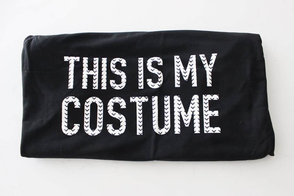 folded black t shirt that says "this is my costume" 