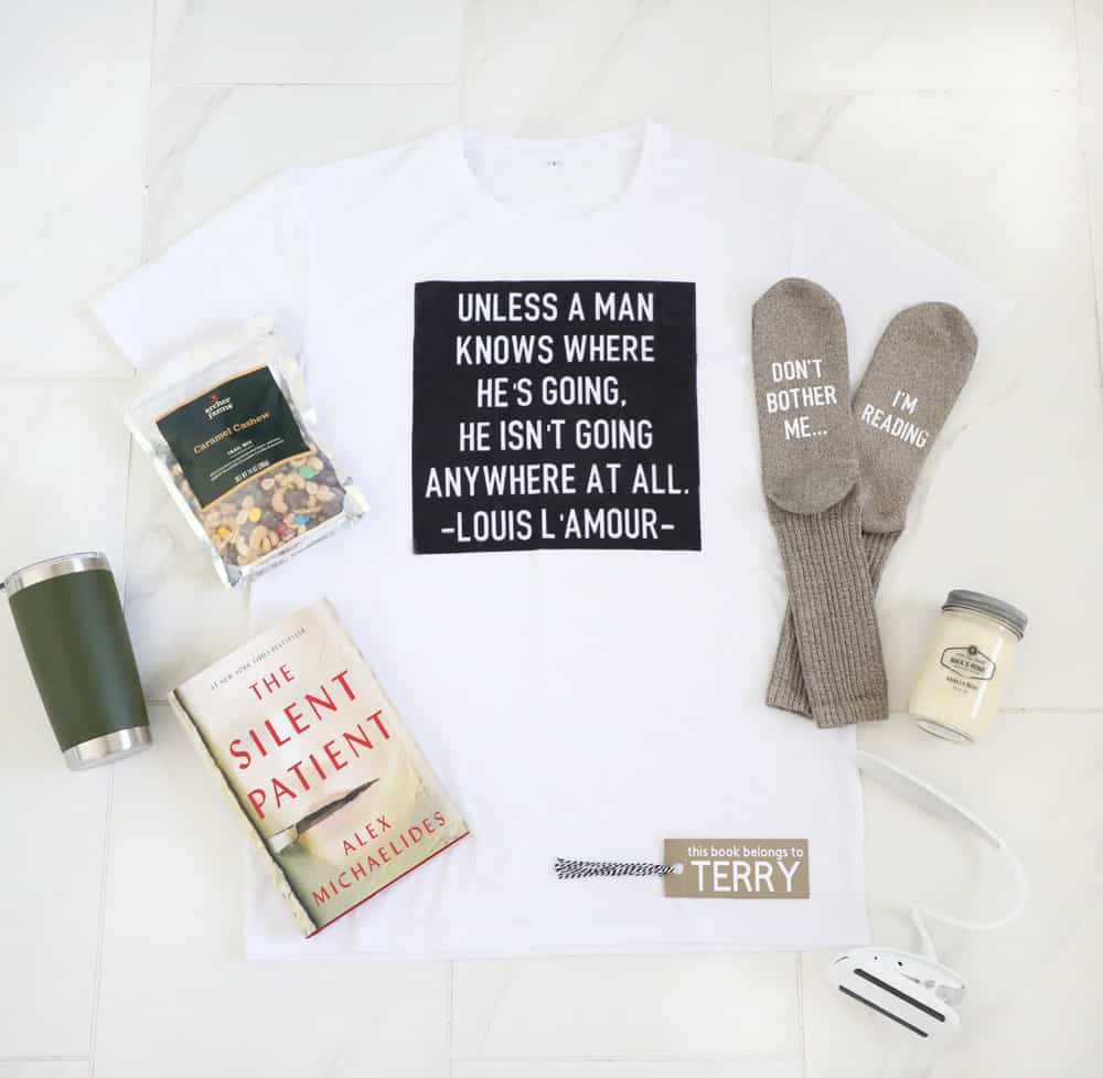 flat lay of a t-shirt, socks, book, reading lamp, bookmark, candle and trail mix