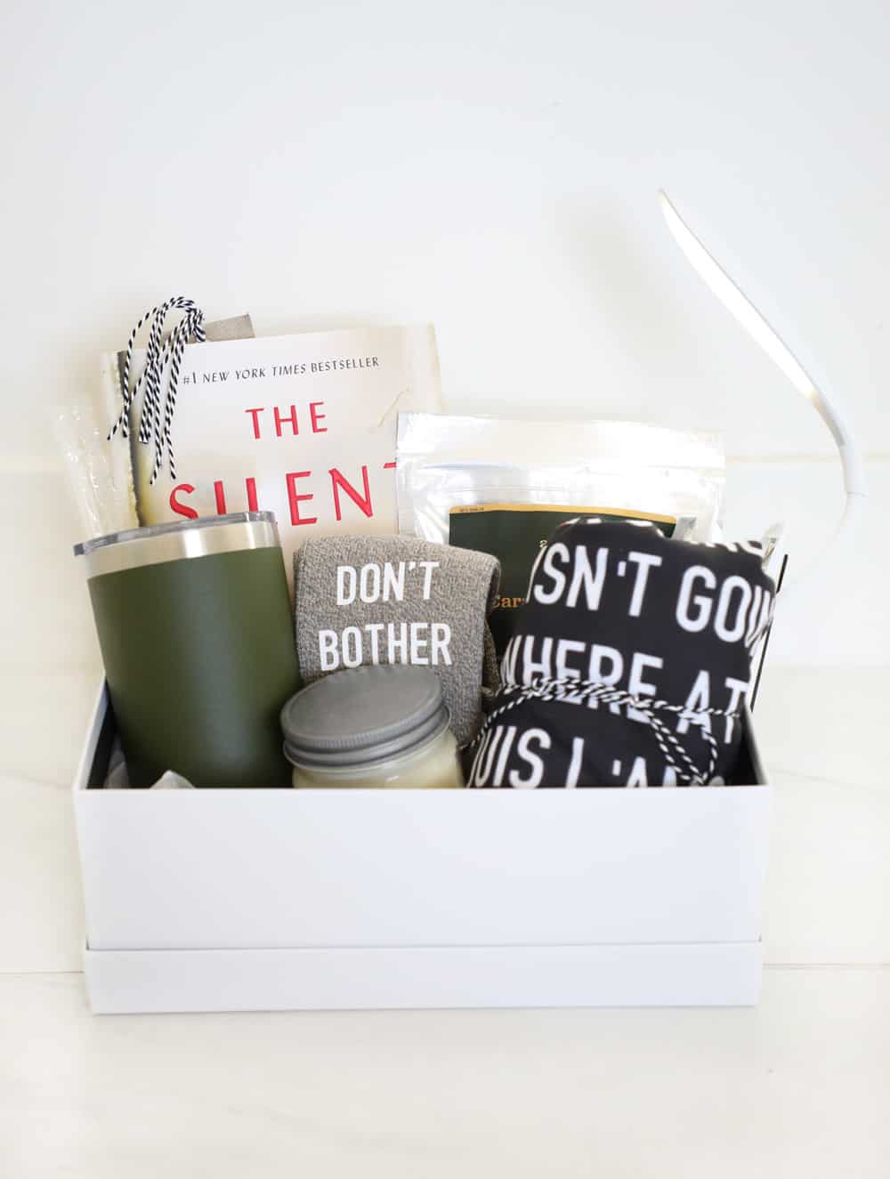 a white box filled with book lover items against a white background