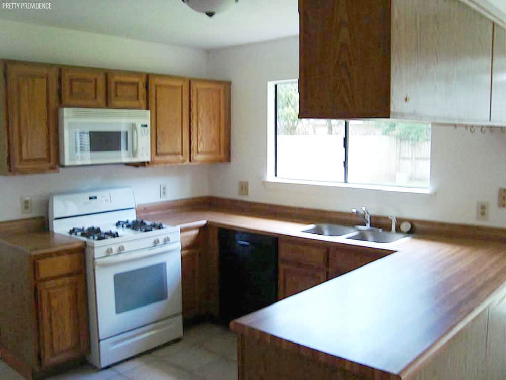 Kitchen Makeover before picture 1980's oak cabinets, mismatched appliances and faux wood laminate counter top.