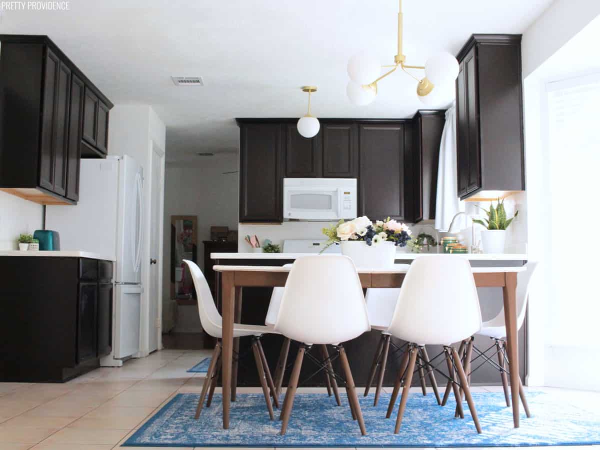 Kitchen makeover with espresso cabinets, white counters, hunter lighting eames style chairs, mid century modern table, blue rugs and accents.
