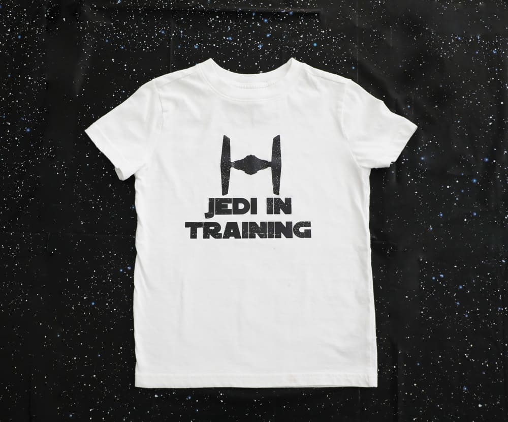 white tee with a fighter pilot and the words "jedi in training" in black