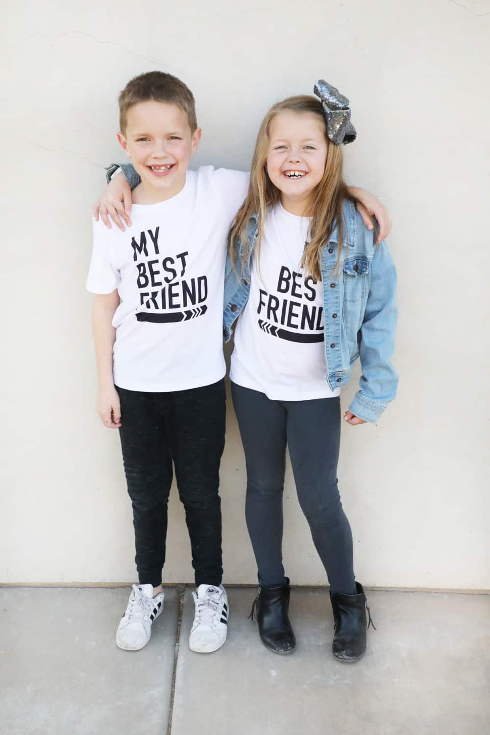 a boy and a girl in white "my best friend" shirts with black writing and arrows pointing toward each other