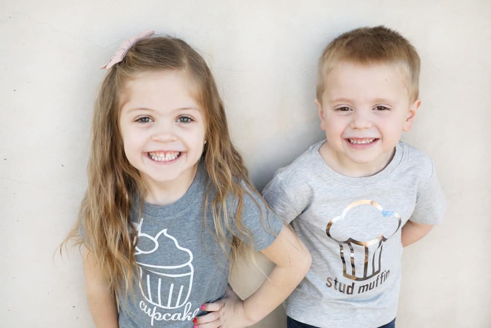 a girl in a grey cupcake shirt and a boy in a lighter grey stud muffin shirt