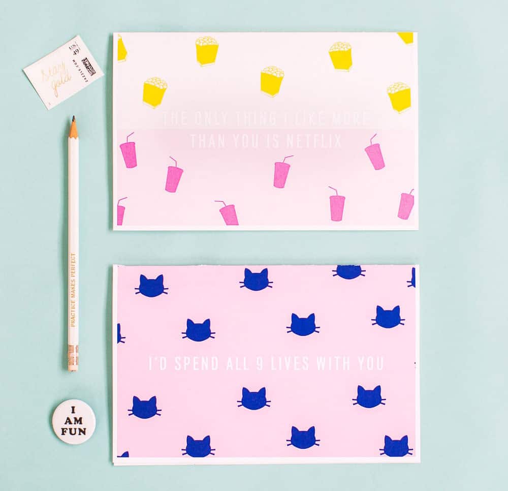 Two cards on a light blue surface, top says "the only thing I like more than you is netflix" and the bottom one says "I'd spend all 9 lives with you" with a cat pattern on it. 