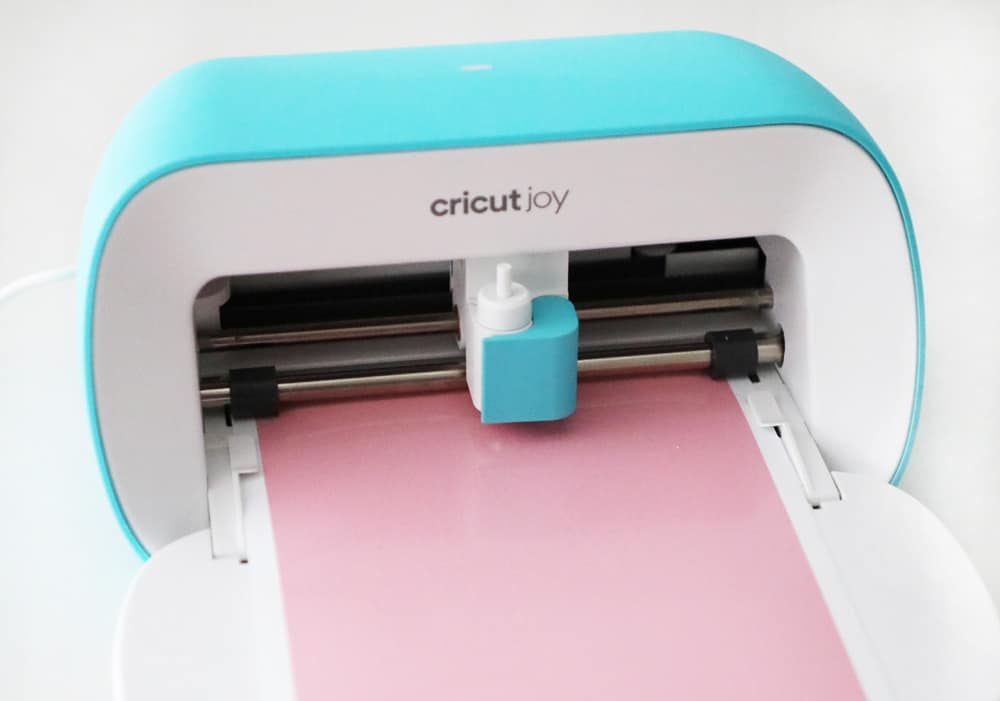 Cricut Joy cutting personalized stickers out of pink vinyl