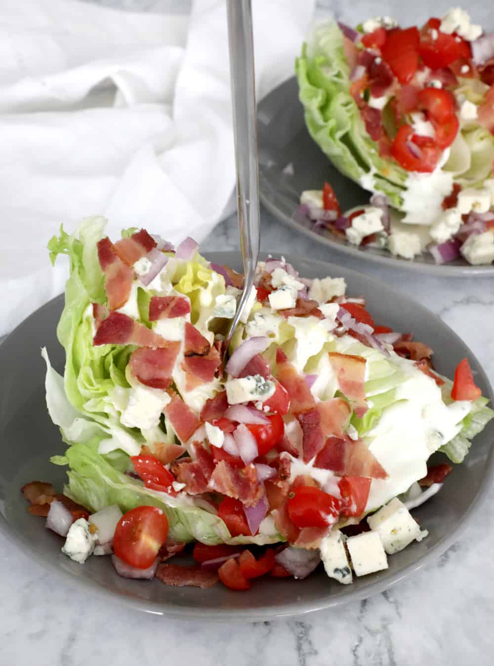 wedge salad with a fork sticking straight out into the air