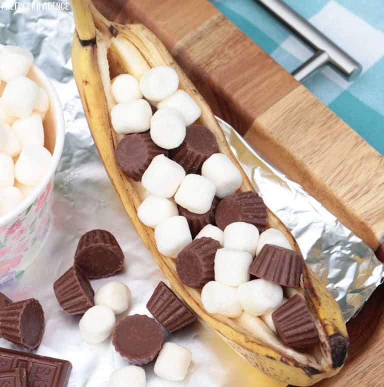 Campfire banana boat dessert - banana stuffed with chocolate and marshmallows on tin foil.