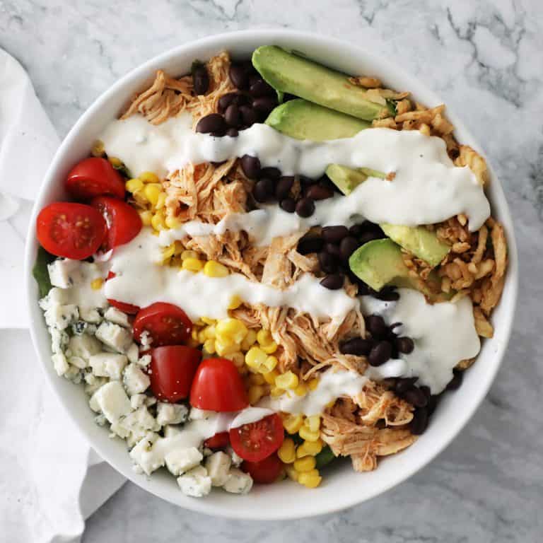 buffalo chicken salad in a white bowl on a granite countertop
