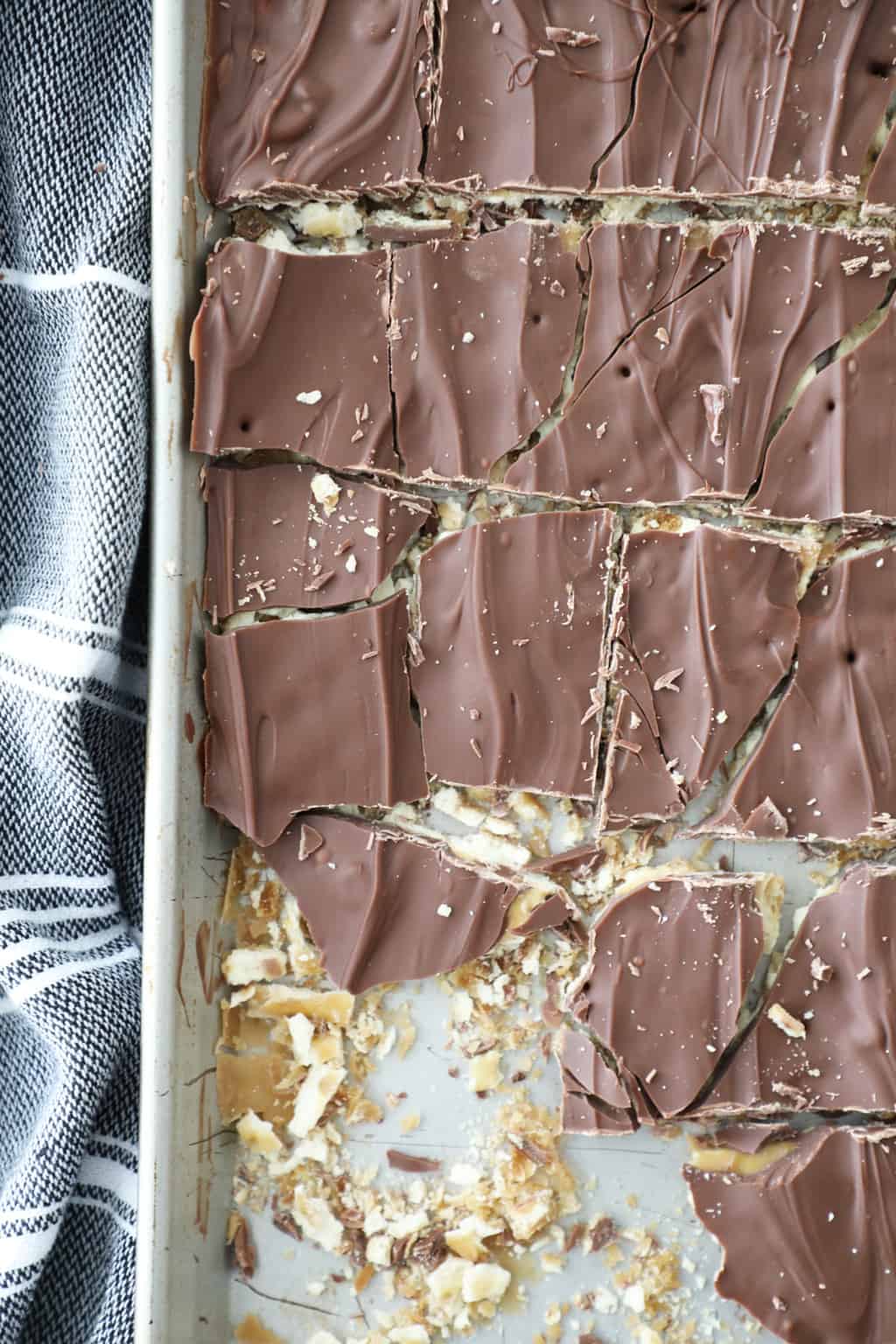 Close up shot of saltine toffee bark in the pan cut into chunks.