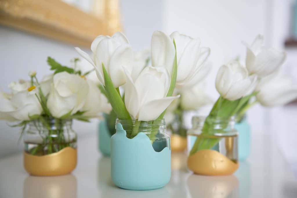 Paint dipped baby food jars with white flowers in them