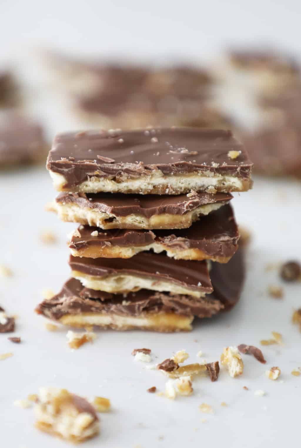 stack of saltine toffee in focus with blurry pieces in the background