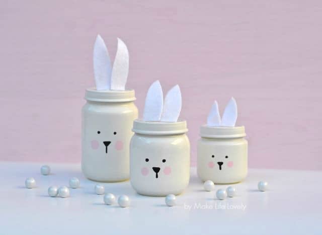 mini easter jars painted white with bunny ears and faces for decoration.