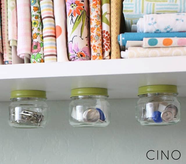 baby food jars screwed onto the underside of a shelf and used as small craft supply storage