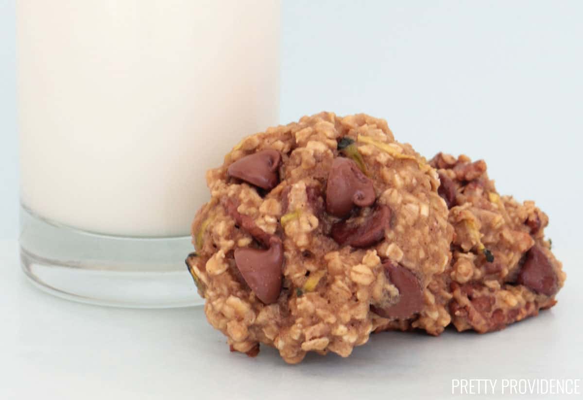 two zucchini breakfast cookies chocolate chip with a glass of milk.