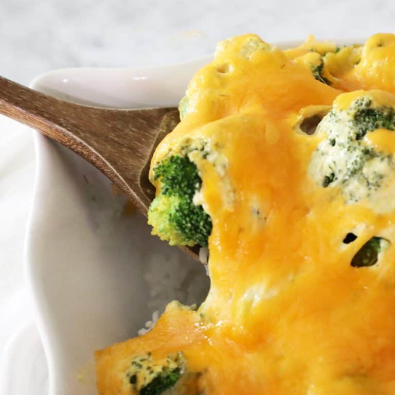 corner of a casserole dish with a scoop of chicken divan on a wooden spoon