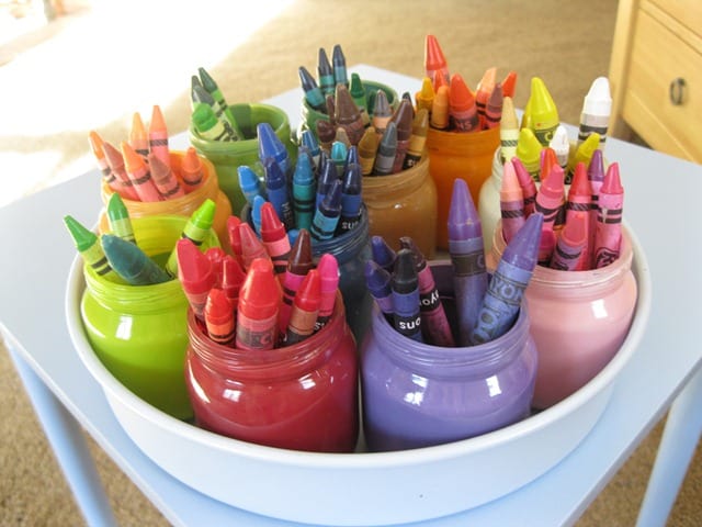 Baby food jars painted colors and crayons sorted into them in a white lazy susan - organized crayons!