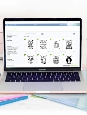 Cricut access on the screen of a Macbook Pro and Cricut supplies around it.