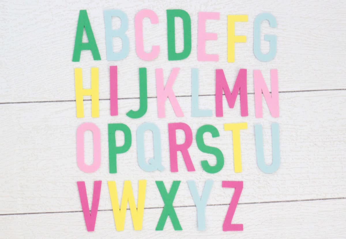 DIY bath letters made with craft foam in green, baby blue, pink, and yellow.