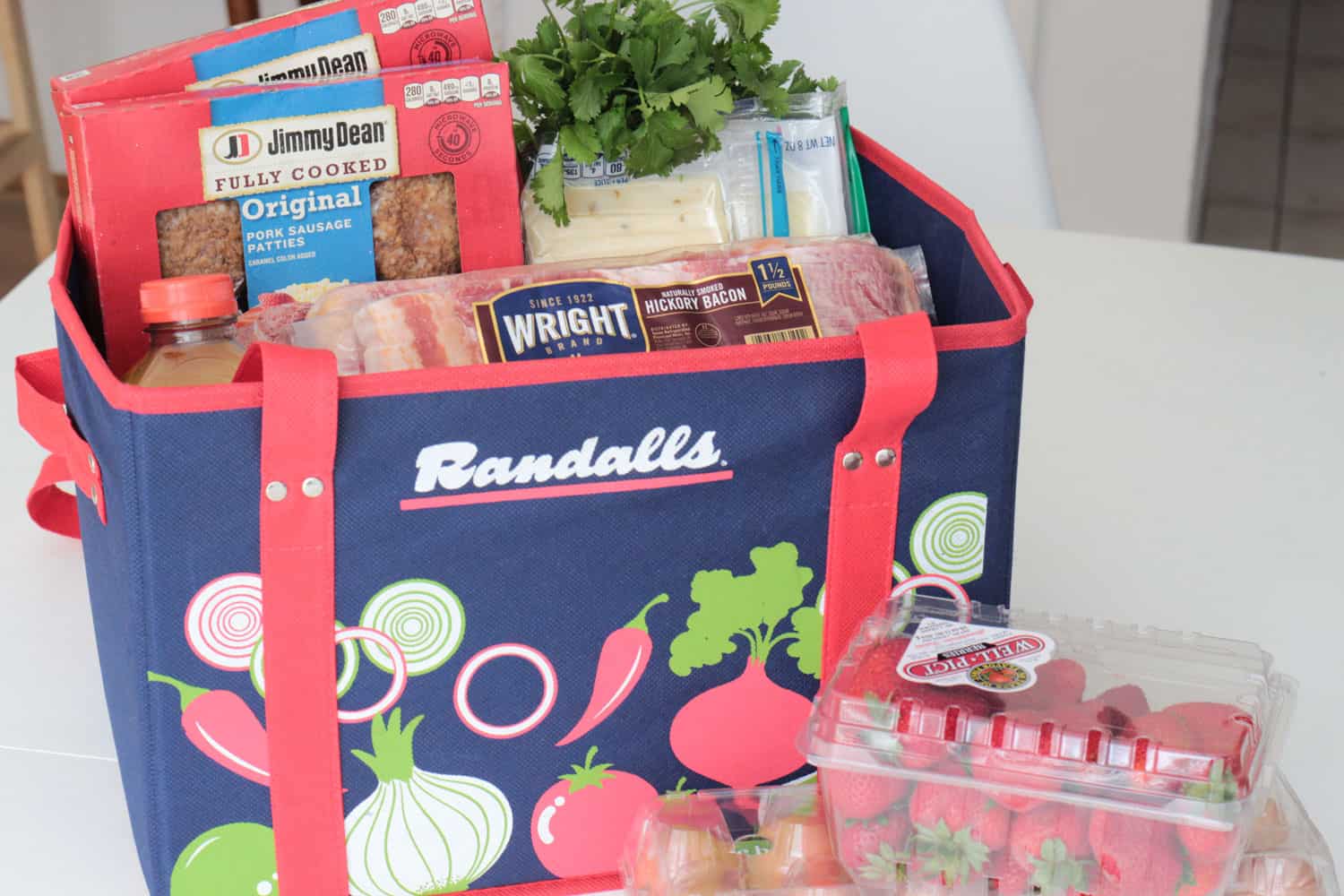 Randall's reusable grocery tote with Wright brand bacon, Jimmy Dean sausage, cheese and cilantro in it.