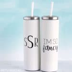 Two white stainless steel tumblers with straws personalized with a monogram and one with 'I'm So Fancy'