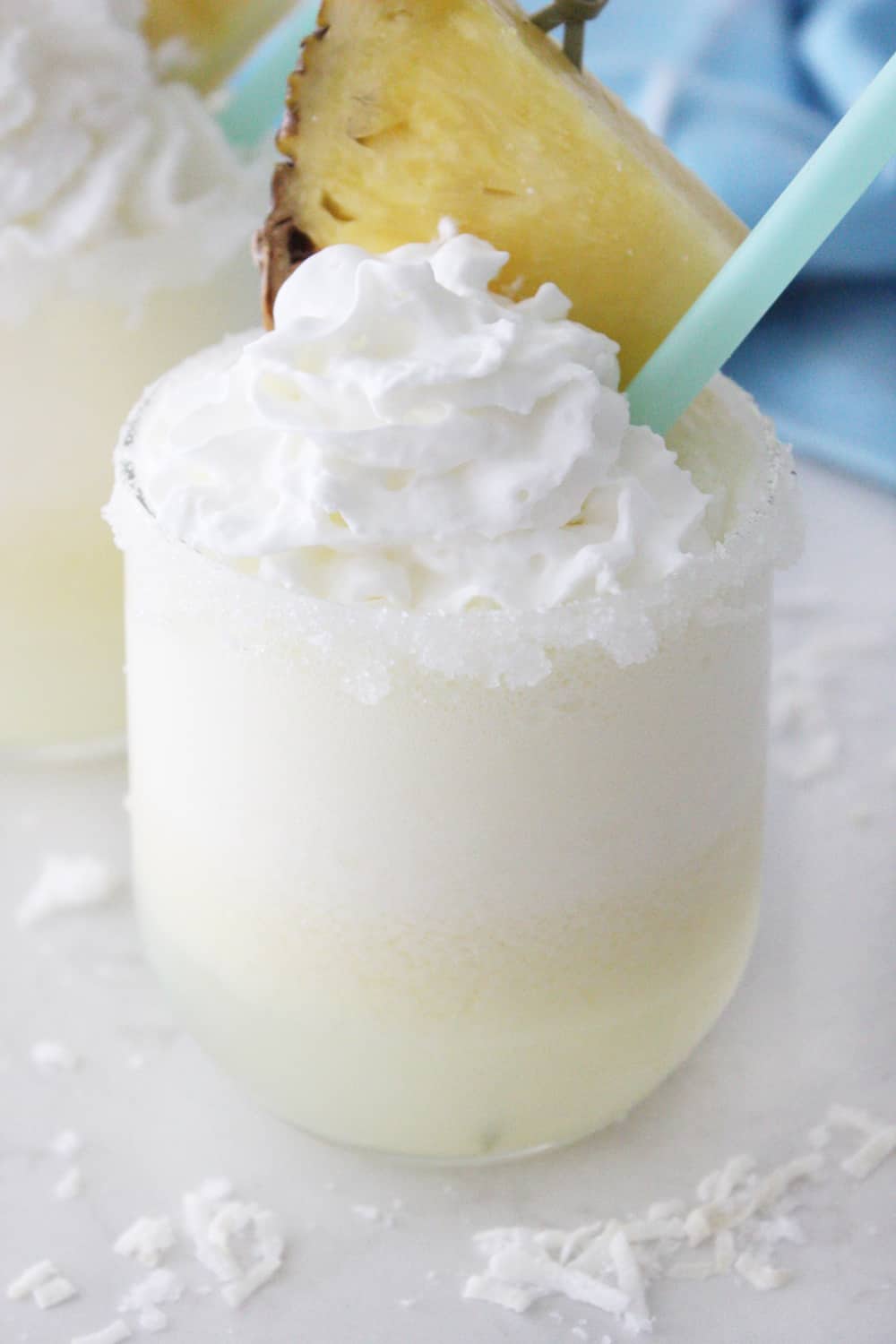 summer drink garnished with whipped cream and a pineapple wedge