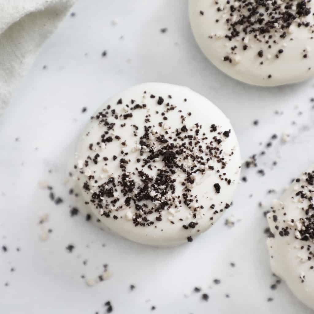 white chocolate oreo covered in oreo crumbs on a granite countertop