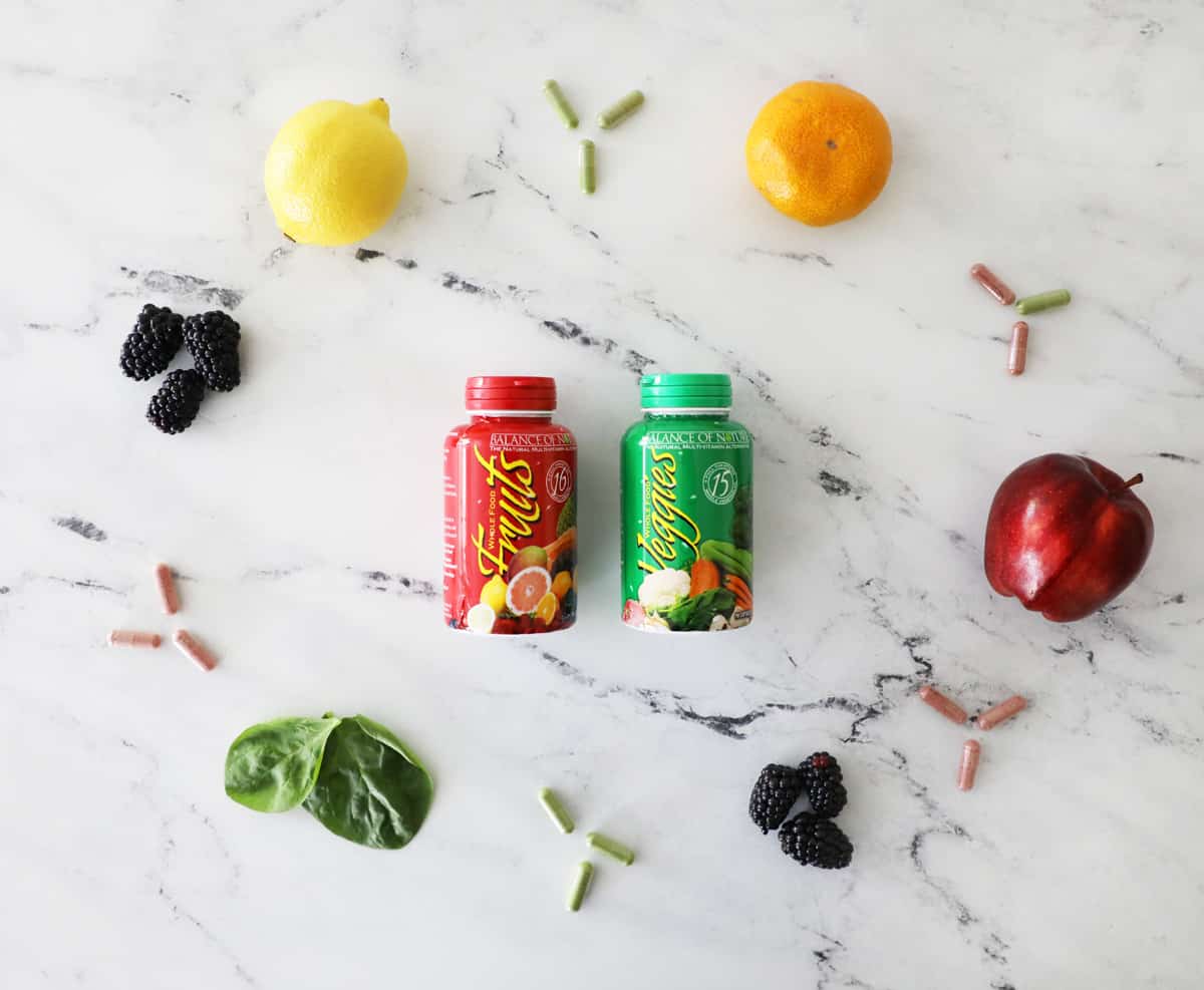 BON fruit and veggie capsules surrounded by fresh fruits and veggies