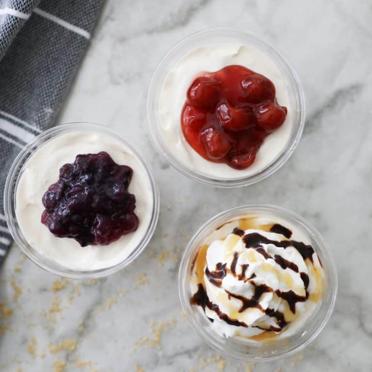 three mini cream cheese pies with different toppings on a granite counter