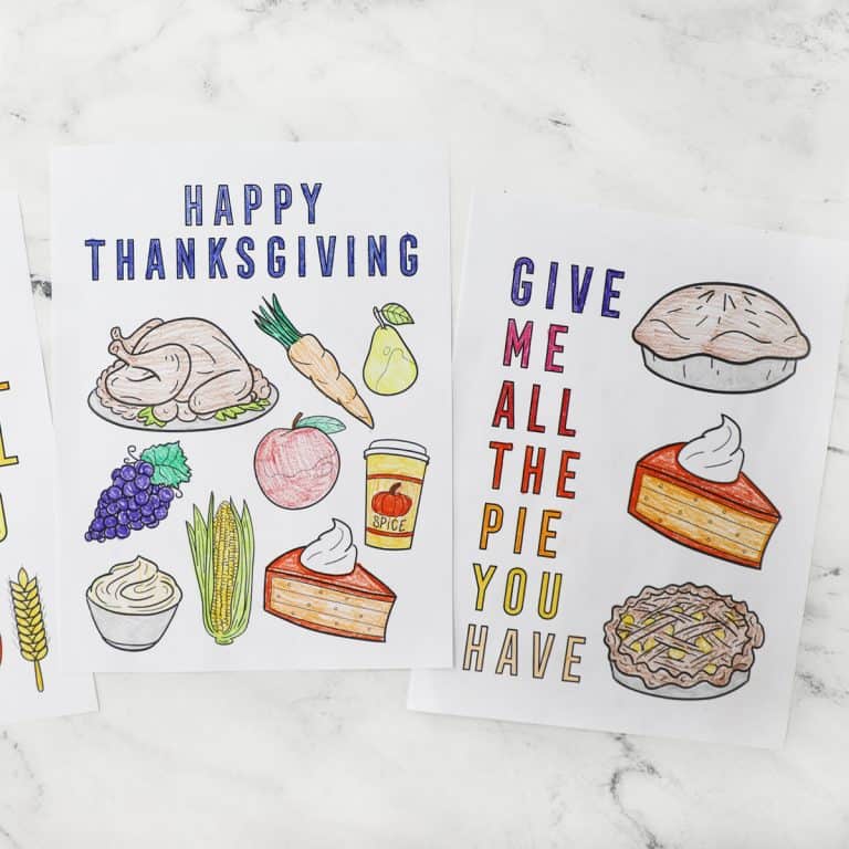 two colored thanksgiving coloring pages on a white counter