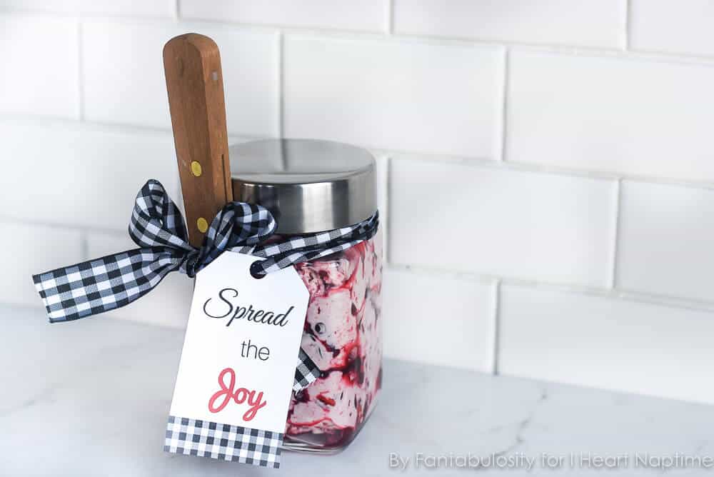 Homemade fruit butter in a jar with a knife, ribbon around it and a tag 'Spread the Joy'