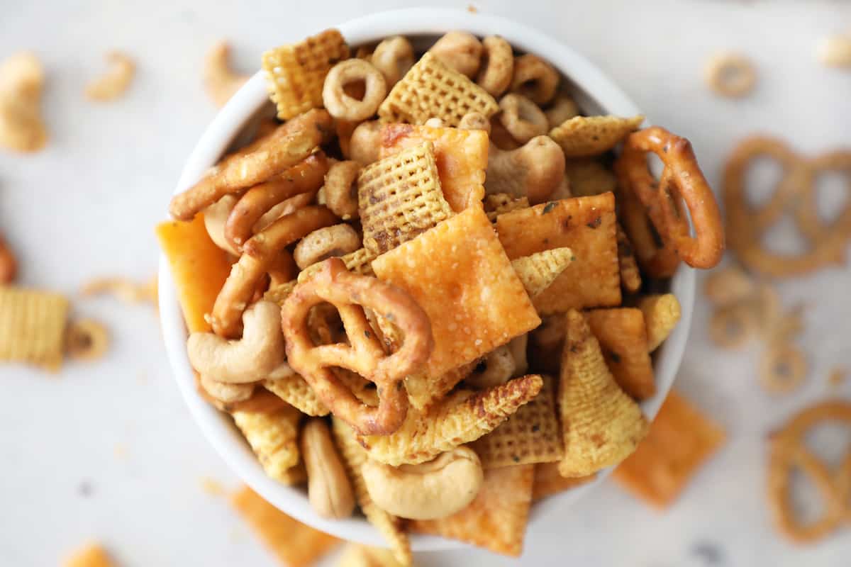 overhead view of homemade Chex mix in a small white bowl overflowing