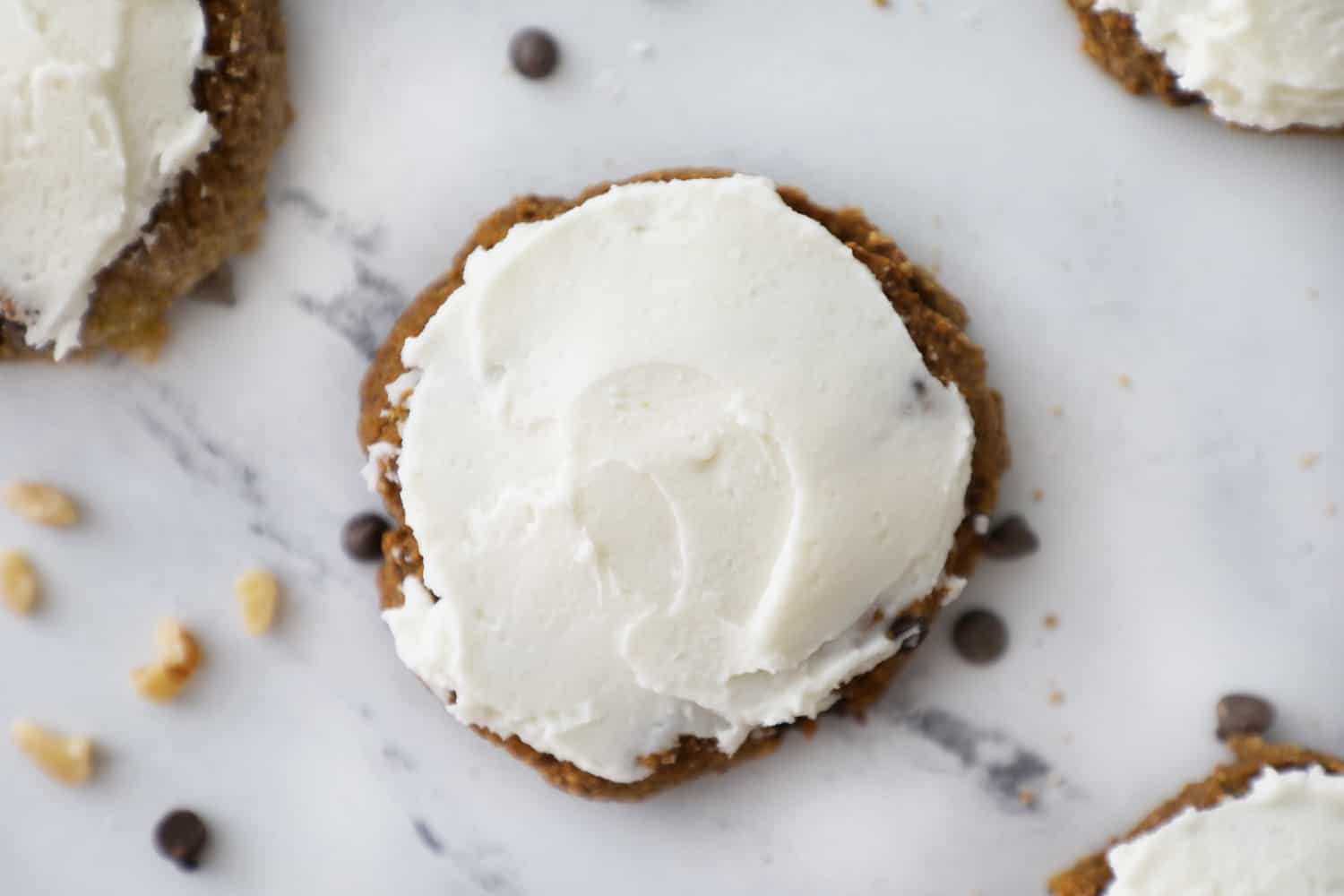 close up of a soft pumpkin oatmeal cookie with cream cheese frosting