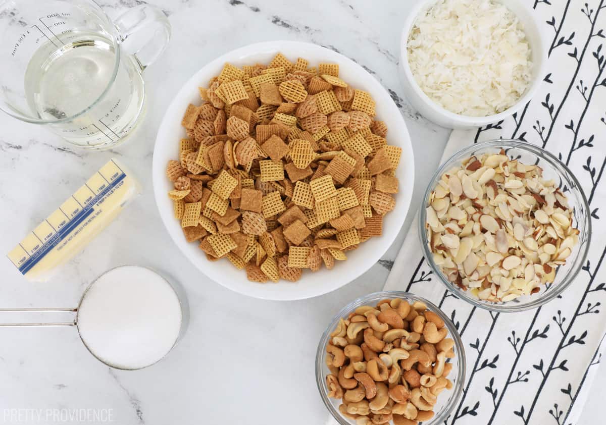 Chex cereal and small bowls of coconut, cashews, almonds and sugar.