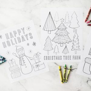 two Christmas themed coloring pages with crayons