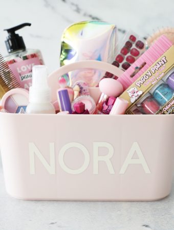 a pink makeup caddy with a name personalized on it filled with supplies