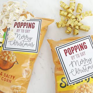 Two bags of kettle corn with bows and Christmas gift tags on the front