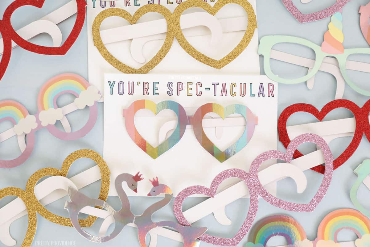 Valentines Heart glasses surrounding a white kids Valentine card that says 'you're spectacular'