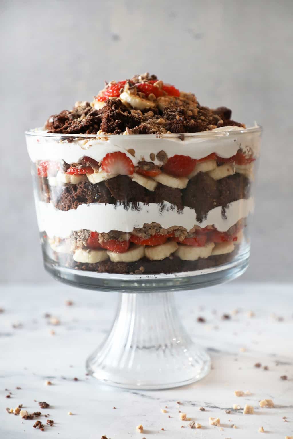 brownie trifle layered in a glass dish against a grey background