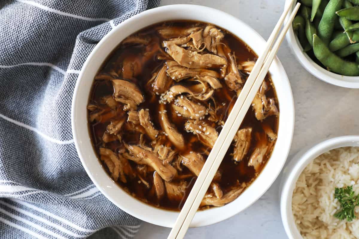 teriyaki chicken shredded in sauce in a white bowl