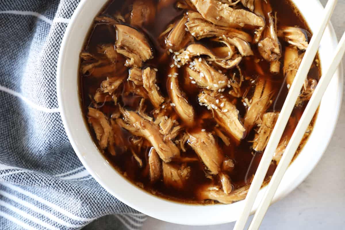 close up of teriyaki chicken in white bowl