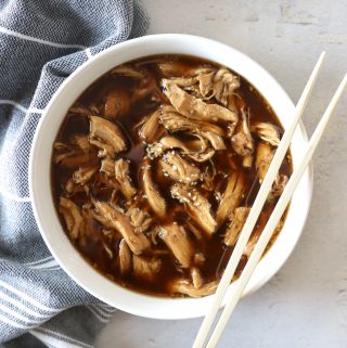 slow cooker teriyaki chicken in a white bowl with chopsticks