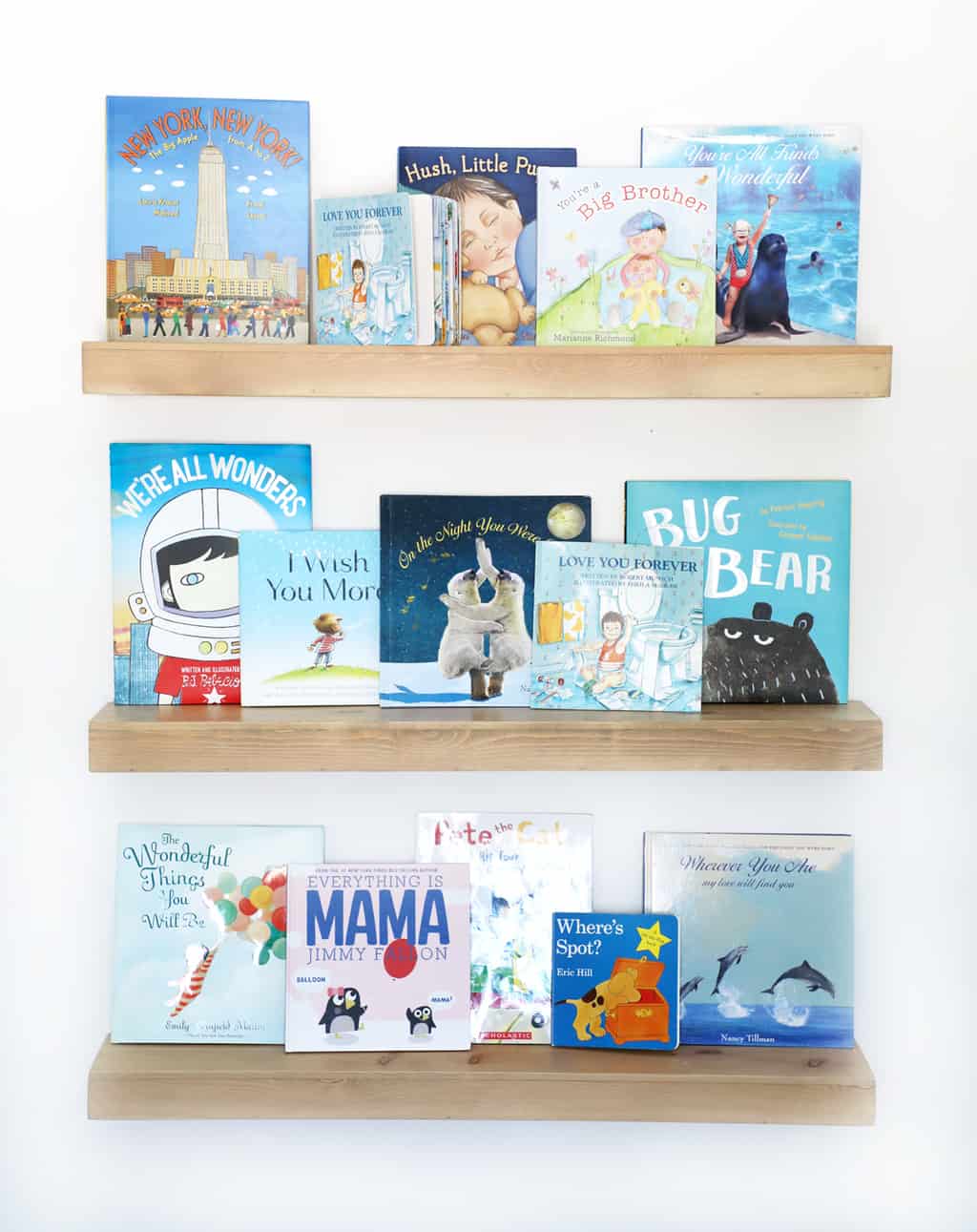 natural wood floating shelves with blue children's books on them