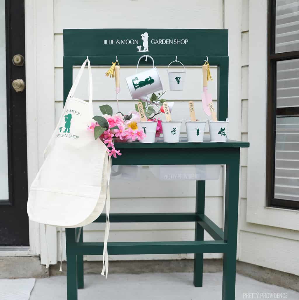 Green water and sensory table with aprons, watering cans and a garden themed sign