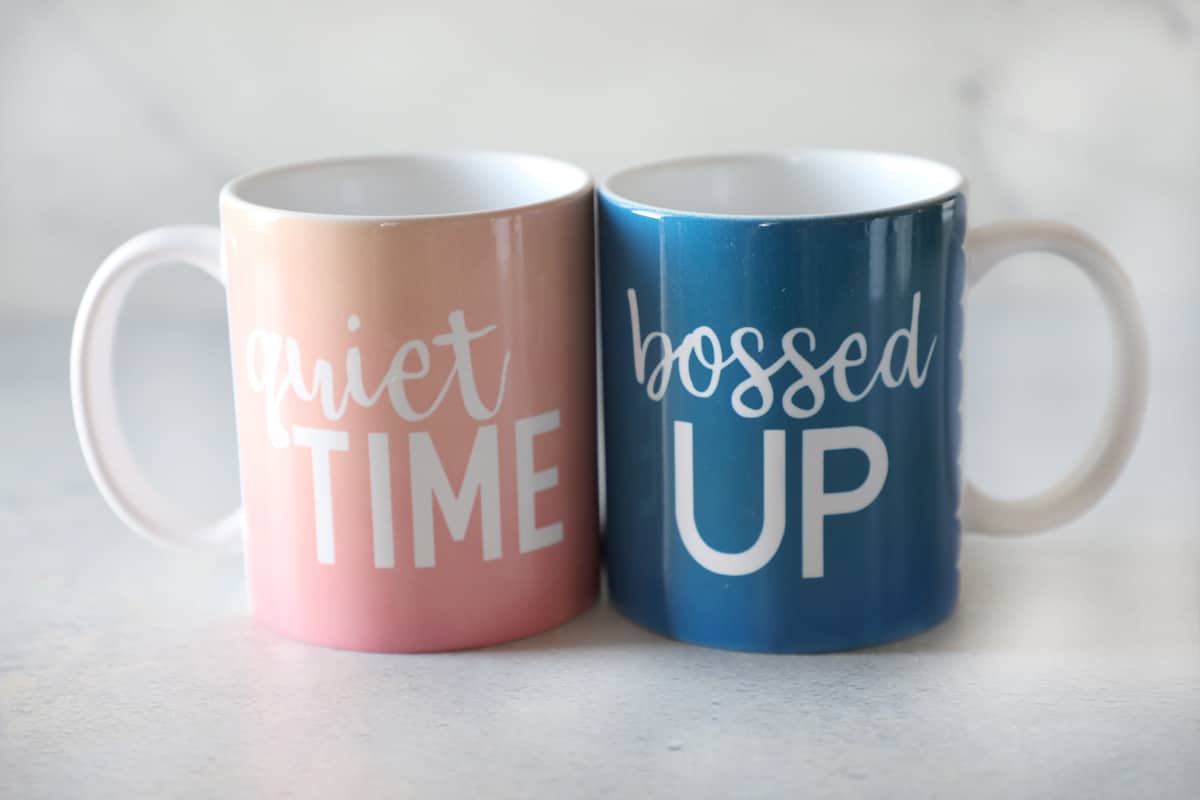 two custom mugs, a pink one that says quiet time and a blue one that says bossed up